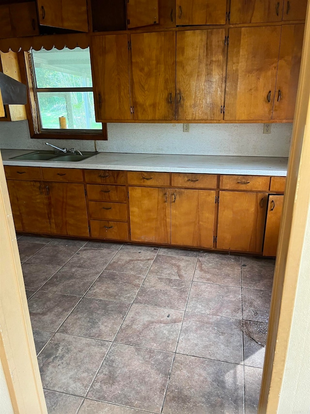 kitchen featuring sink and dark tile flooring