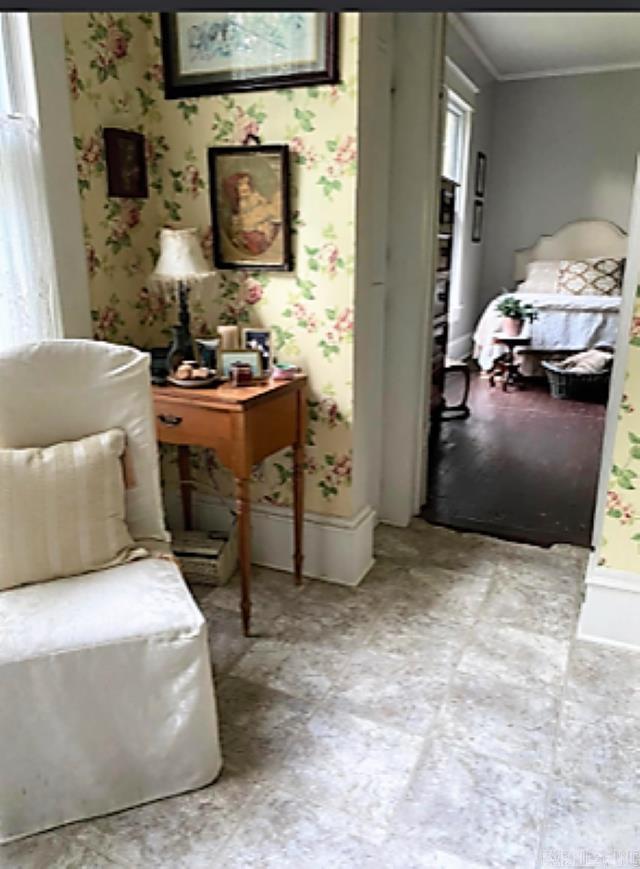 living area with light tile floors and ornamental molding