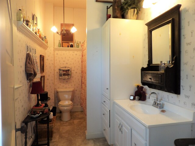 bathroom with toilet, large vanity, and tile flooring