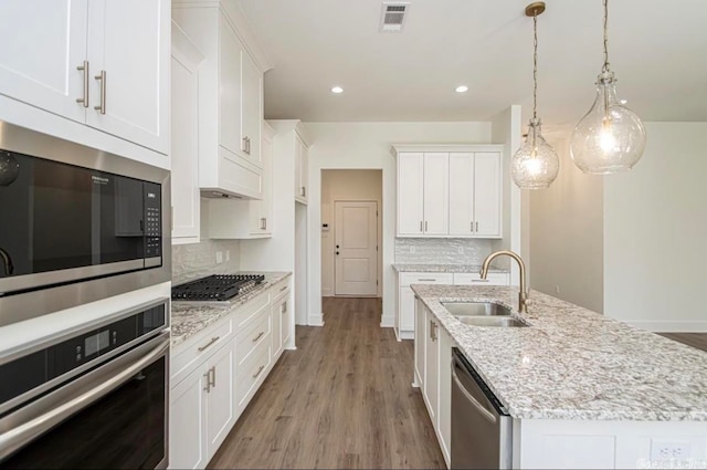 kitchen with light hardwood / wood-style flooring, sink, stainless steel appliances, and backsplash