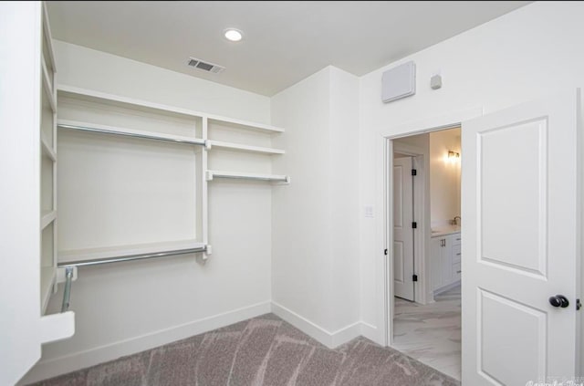 walk in closet featuring light colored carpet