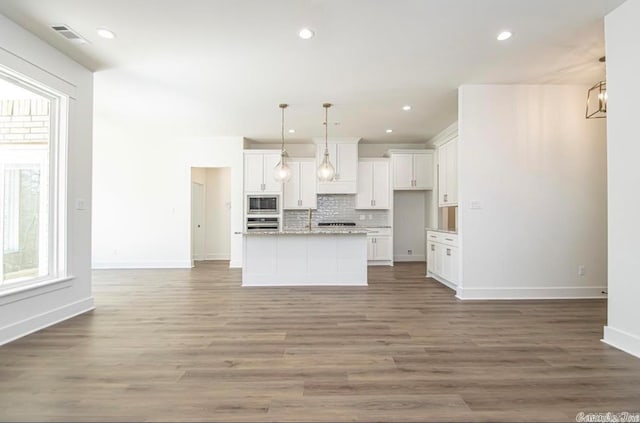 kitchen with white cabinets, light wood-type flooring, and stainless steel appliances