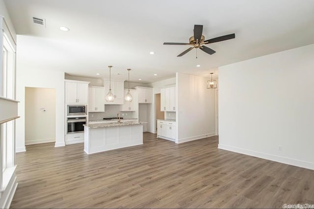 kitchen featuring white cabinets, appliances with stainless steel finishes, and hardwood / wood-style flooring