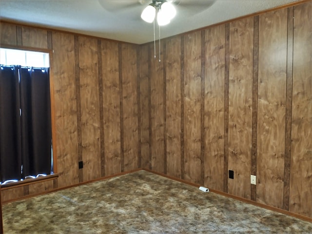 carpeted empty room with wooden walls and ceiling fan