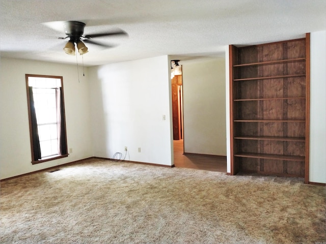 unfurnished bedroom with a textured ceiling, ceiling fan, and dark carpet