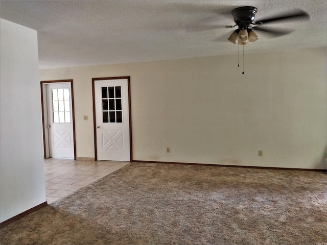 carpeted spare room featuring ceiling fan and a textured ceiling