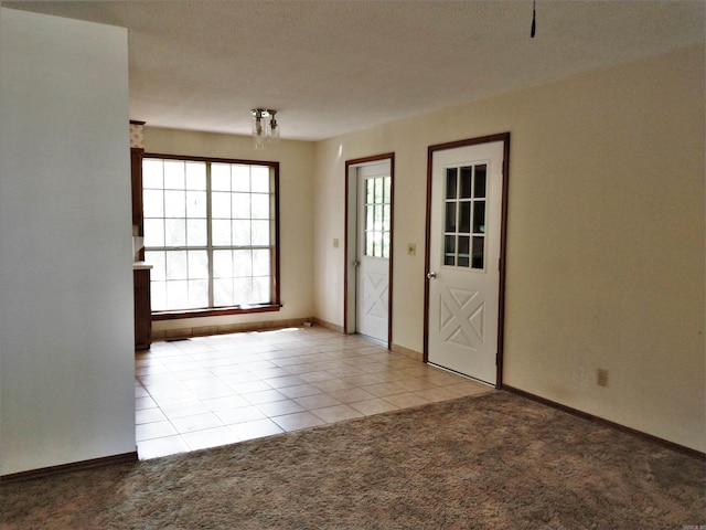 unfurnished room with a textured ceiling and light carpet