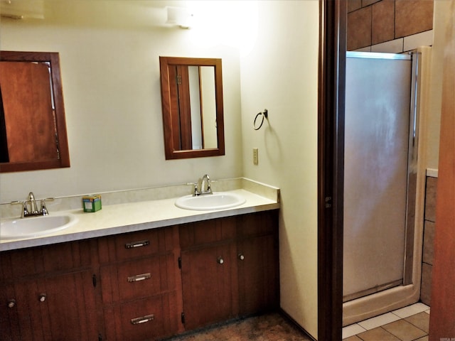 bathroom featuring double sink vanity, tile floors, and a shower with door