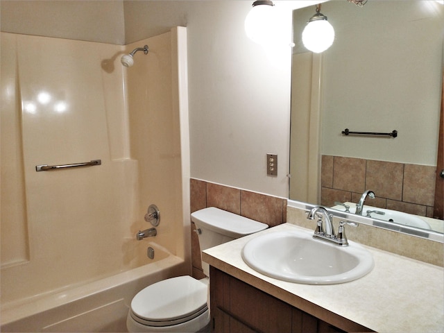 full bathroom featuring tile walls, toilet, vanity, and shower / tub combination