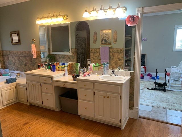 bathroom with double vanity and hardwood / wood-style flooring