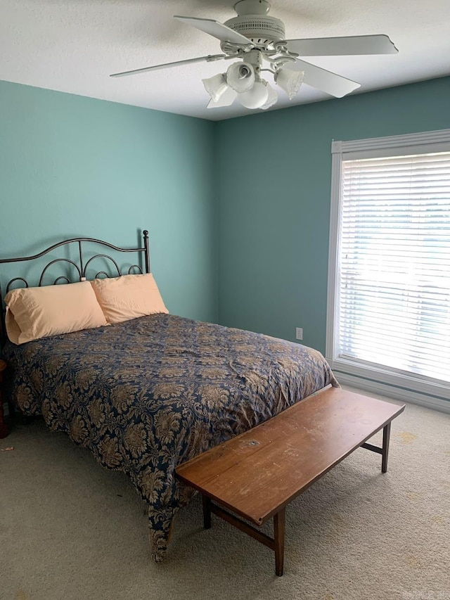 bedroom featuring carpet flooring, ceiling fan, and multiple windows