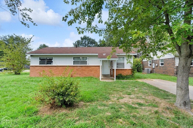 ranch-style home with a front lawn and central air condition unit