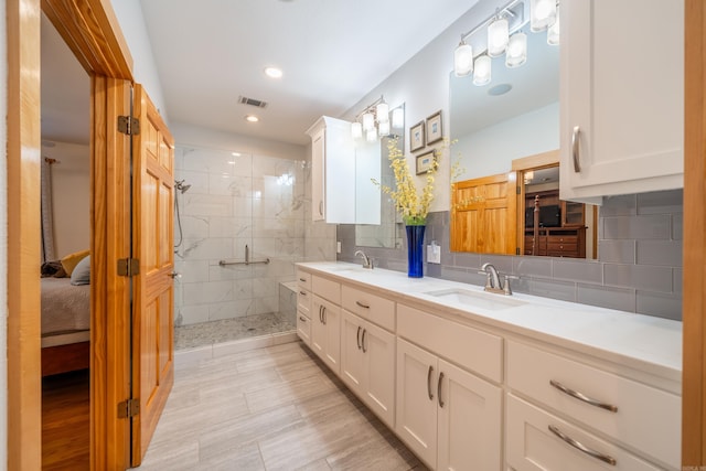 bathroom with tile flooring, double sink vanity, backsplash, and a tile shower