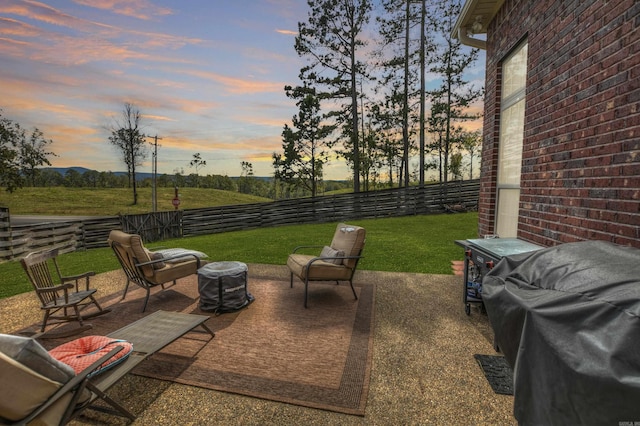 patio terrace at dusk featuring a yard