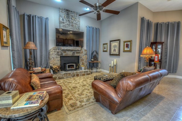 living room featuring ceiling fan, a fireplace, and light tile floors