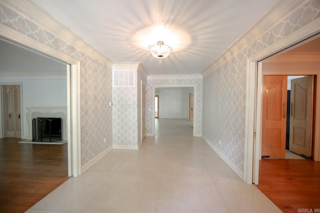 hall with ornamental molding and light tile floors