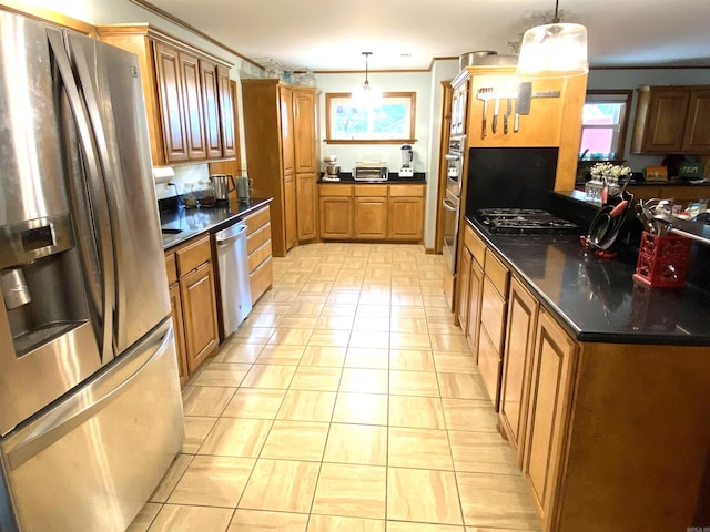 kitchen with a healthy amount of sunlight, stainless steel appliances, and decorative light fixtures