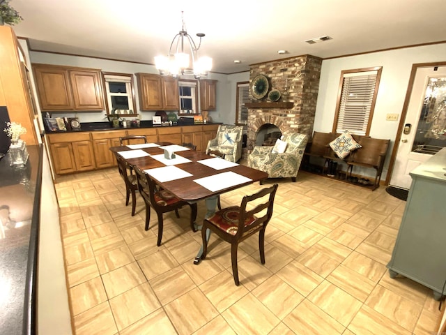 dining room featuring brick wall, a fireplace, a chandelier, and light tile floors