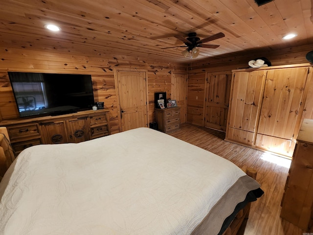 bedroom featuring wooden ceiling, ceiling fan, wood walls, and dark hardwood / wood-style floors