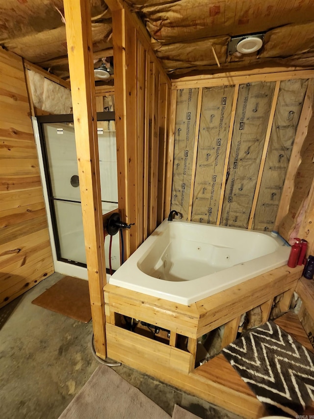 bathroom with wood walls and a bathtub