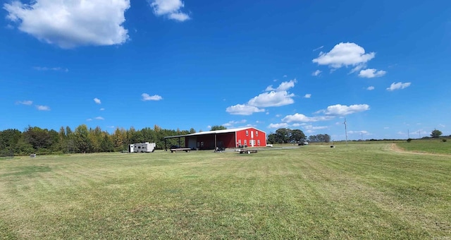 view of yard with a rural view and an outdoor structure