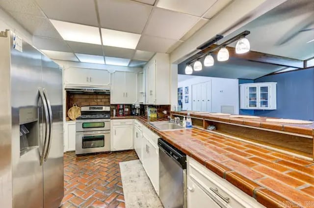 kitchen with white cabinetry, tile countertops, and appliances with stainless steel finishes