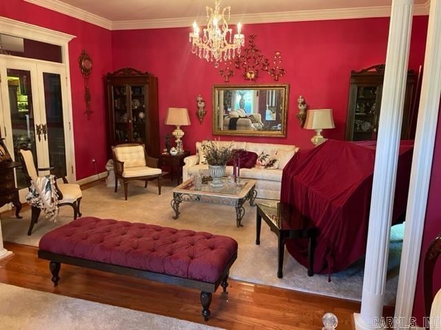 interior space featuring a chandelier, french doors, hardwood / wood-style flooring, and crown molding