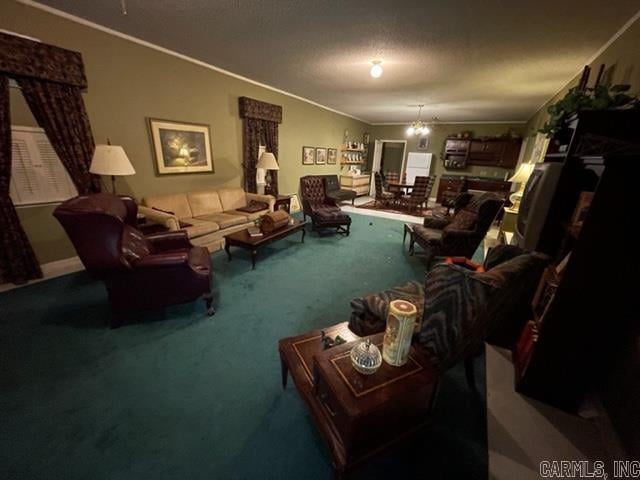 living room featuring ornamental molding, carpet floors, and a notable chandelier