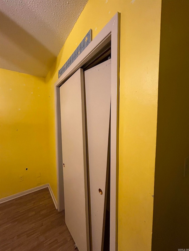 hall featuring dark hardwood / wood-style flooring and a textured ceiling