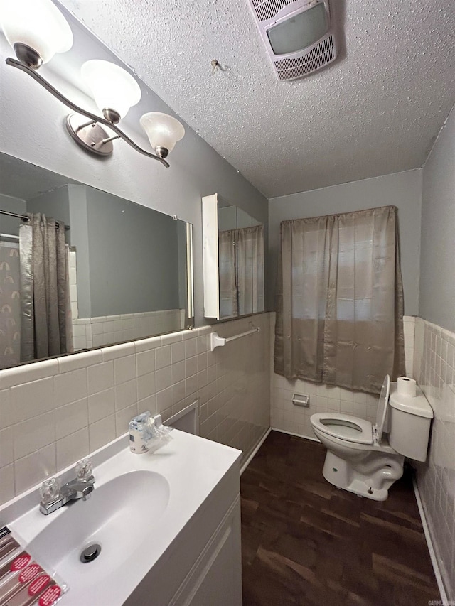bathroom featuring hardwood / wood-style floors, backsplash, tile walls, toilet, and large vanity