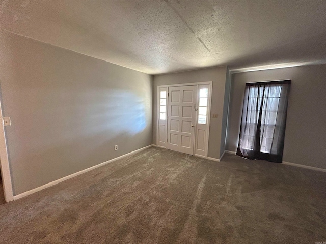 carpeted foyer with a textured ceiling