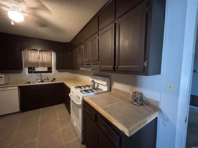 kitchen with light tile flooring, white appliances, a textured ceiling, sink, and dark brown cabinetry