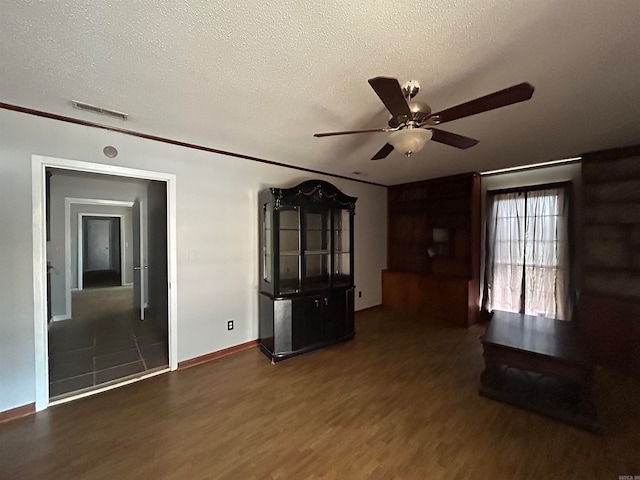 unfurnished living room featuring a textured ceiling, ceiling fan, and dark hardwood / wood-style floors