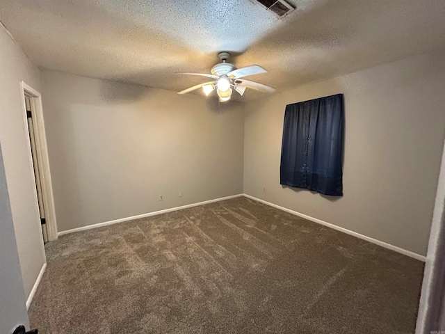 empty room with a textured ceiling, ceiling fan, and dark carpet