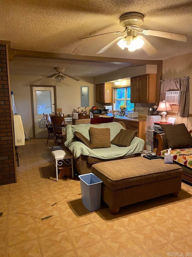 living room featuring ceiling fan and a textured ceiling