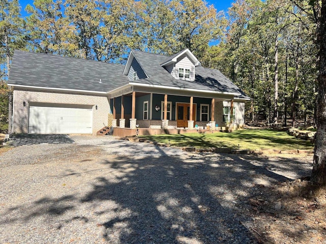 view of front of house featuring a garage, a porch, and a front yard