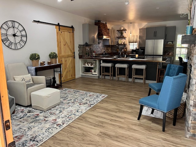 living room featuring light hardwood / wood-style flooring and a barn door