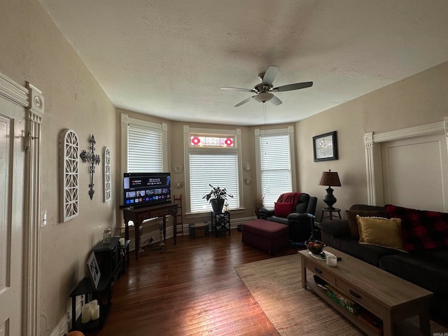 living room featuring ceiling fan, a textured ceiling, and dark hardwood / wood-style floors