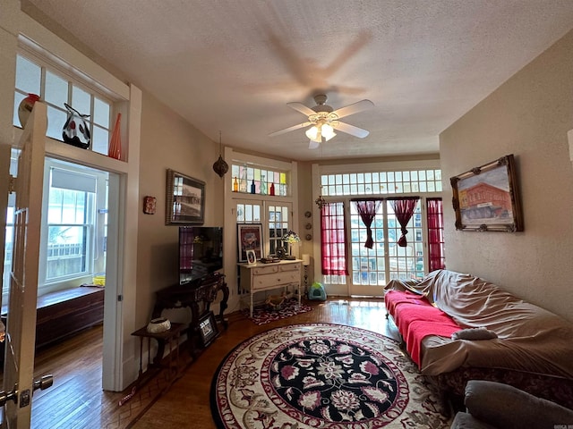 living room with french doors, a textured ceiling, ceiling fan, and dark hardwood / wood-style flooring