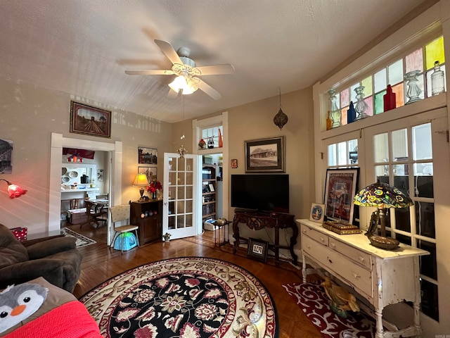 living room featuring dark hardwood / wood-style floors, a textured ceiling, ceiling fan, and french doors