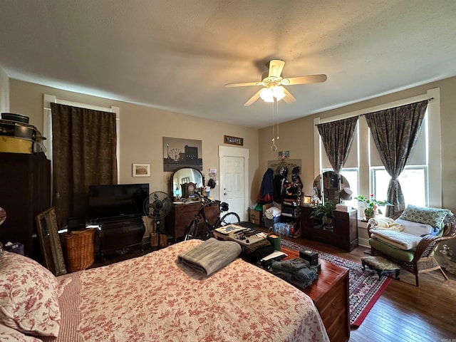 bedroom with dark hardwood / wood-style flooring and ceiling fan