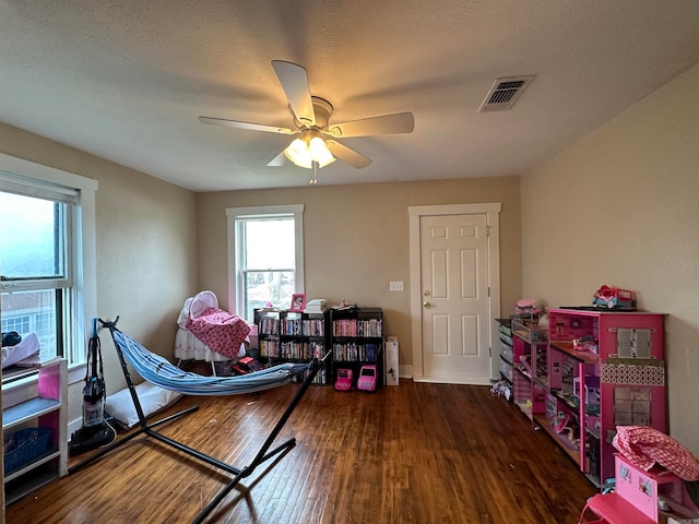 recreation room featuring ceiling fan and dark hardwood / wood-style flooring