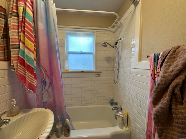 bathroom with shower / bath combo with shower curtain and sink