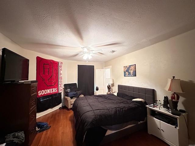 bedroom featuring a textured ceiling, ceiling fan, and dark hardwood / wood-style floors