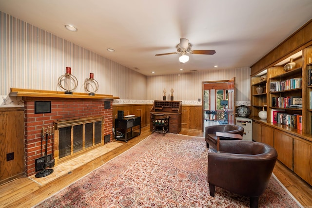 office with a brick fireplace, light hardwood / wood-style floors, and ceiling fan