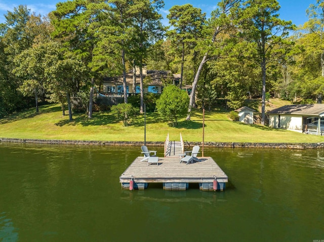 view of dock with a lawn and a water view