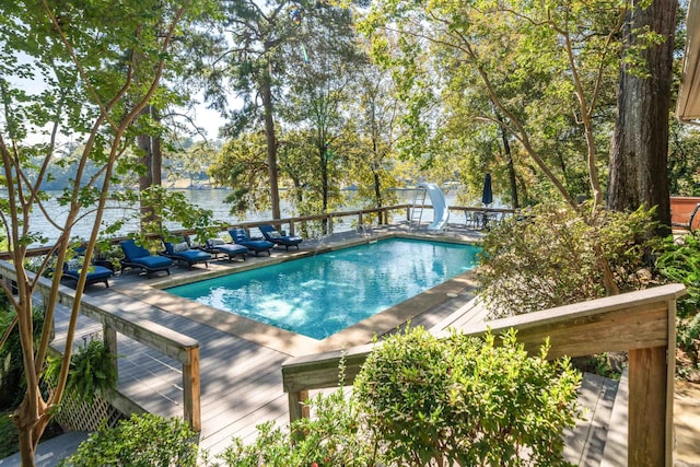 view of swimming pool featuring a water slide and a deck