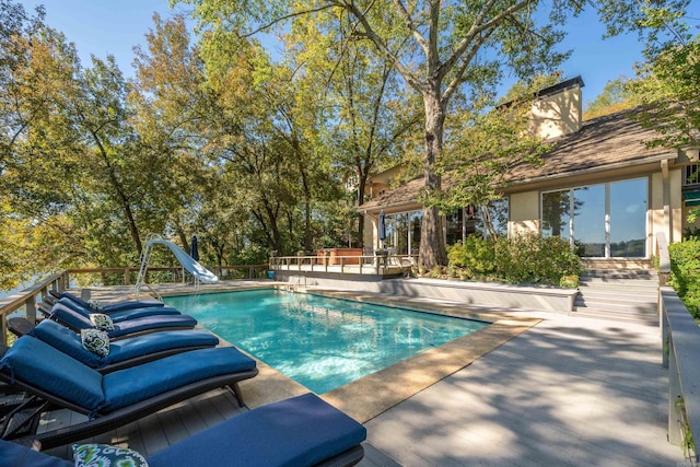 view of swimming pool featuring a water slide and a patio area