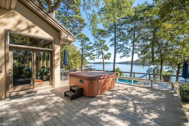 deck featuring a water view and a hot tub