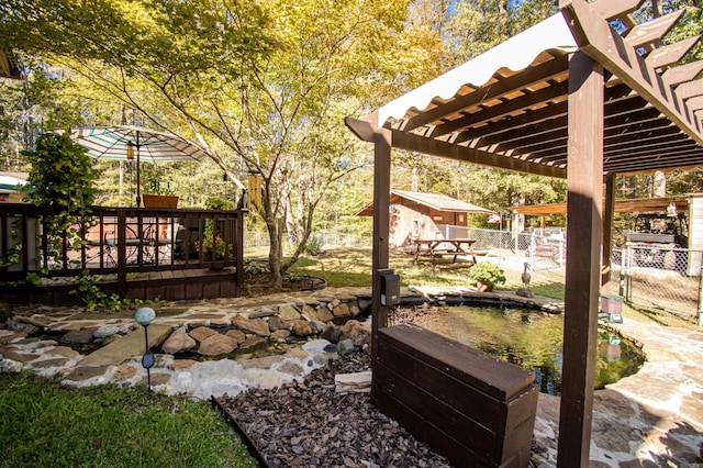 view of yard featuring a wooden deck, a pergola, and a patio